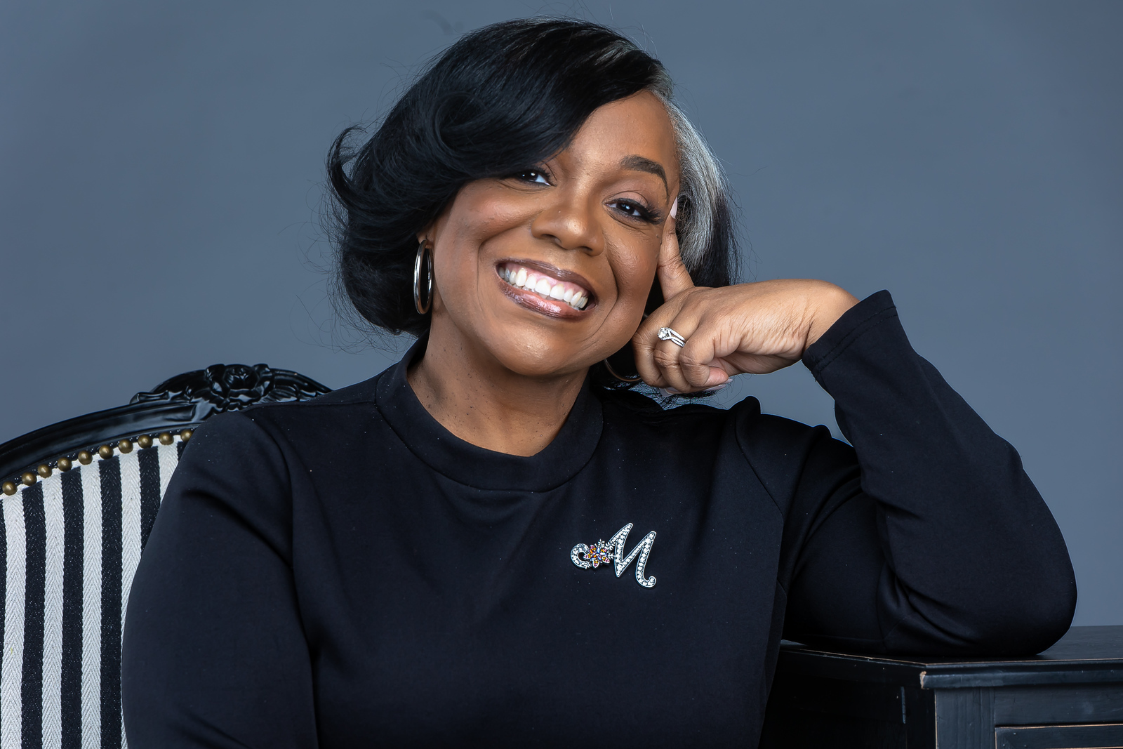 Studio portrait of Marsha resting her chin on her hand, smiling.