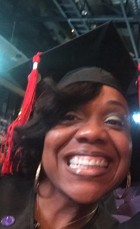 Marsha smiling in her graduation cap and tassel.