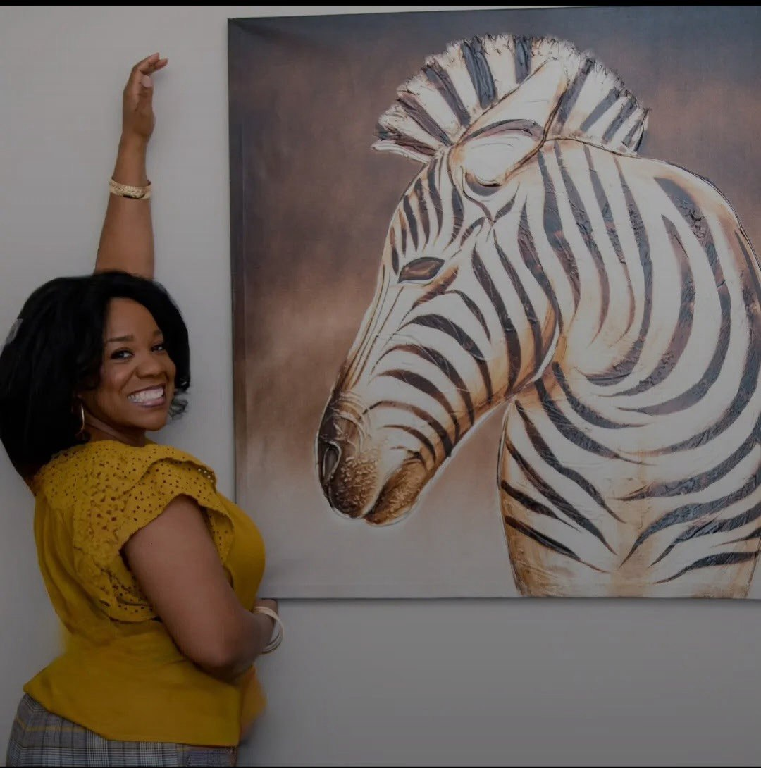 Marsha beside a zebra painting.